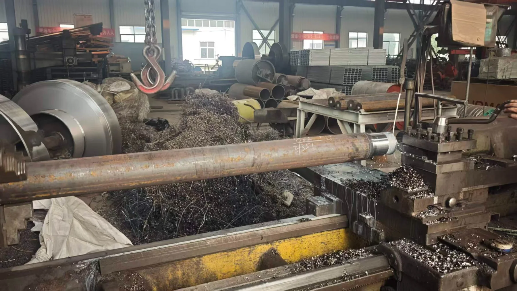 Long conveyor shaft being machined on a lathe in the Junxin workshop
