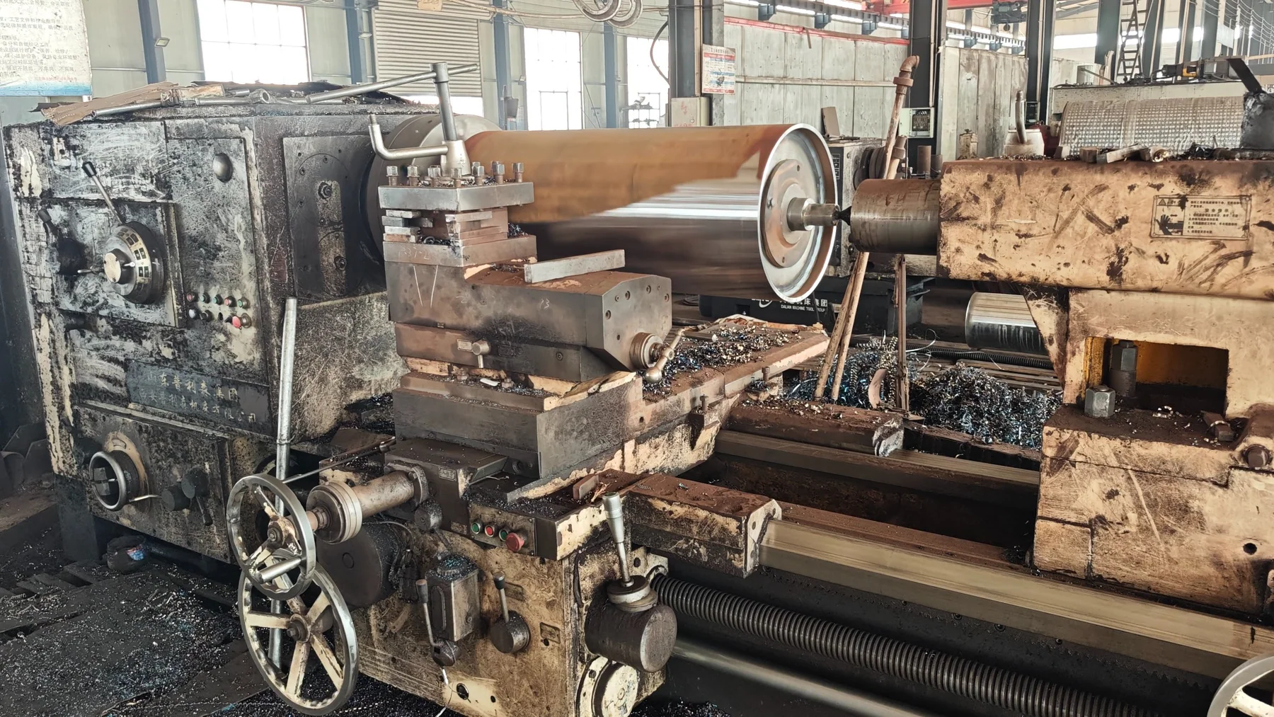 Large conveyor pulley turning on a workshop lathe