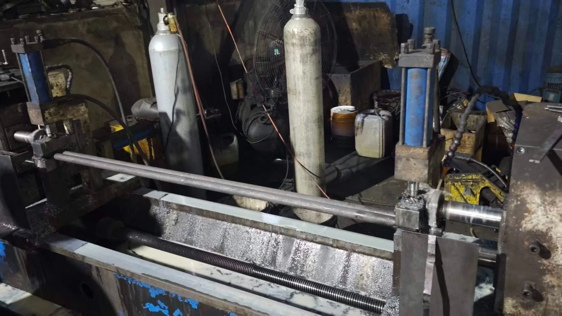 Conveyor shaft end being machined between workshop fixtures