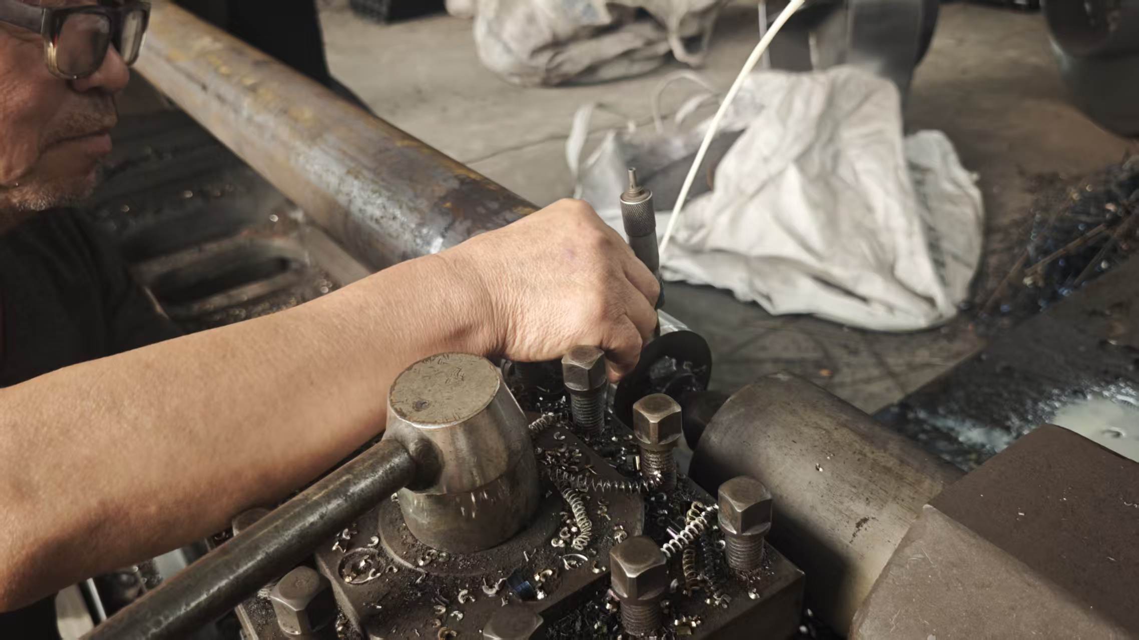 Junxin machinist turning a conveyor component on a lathe