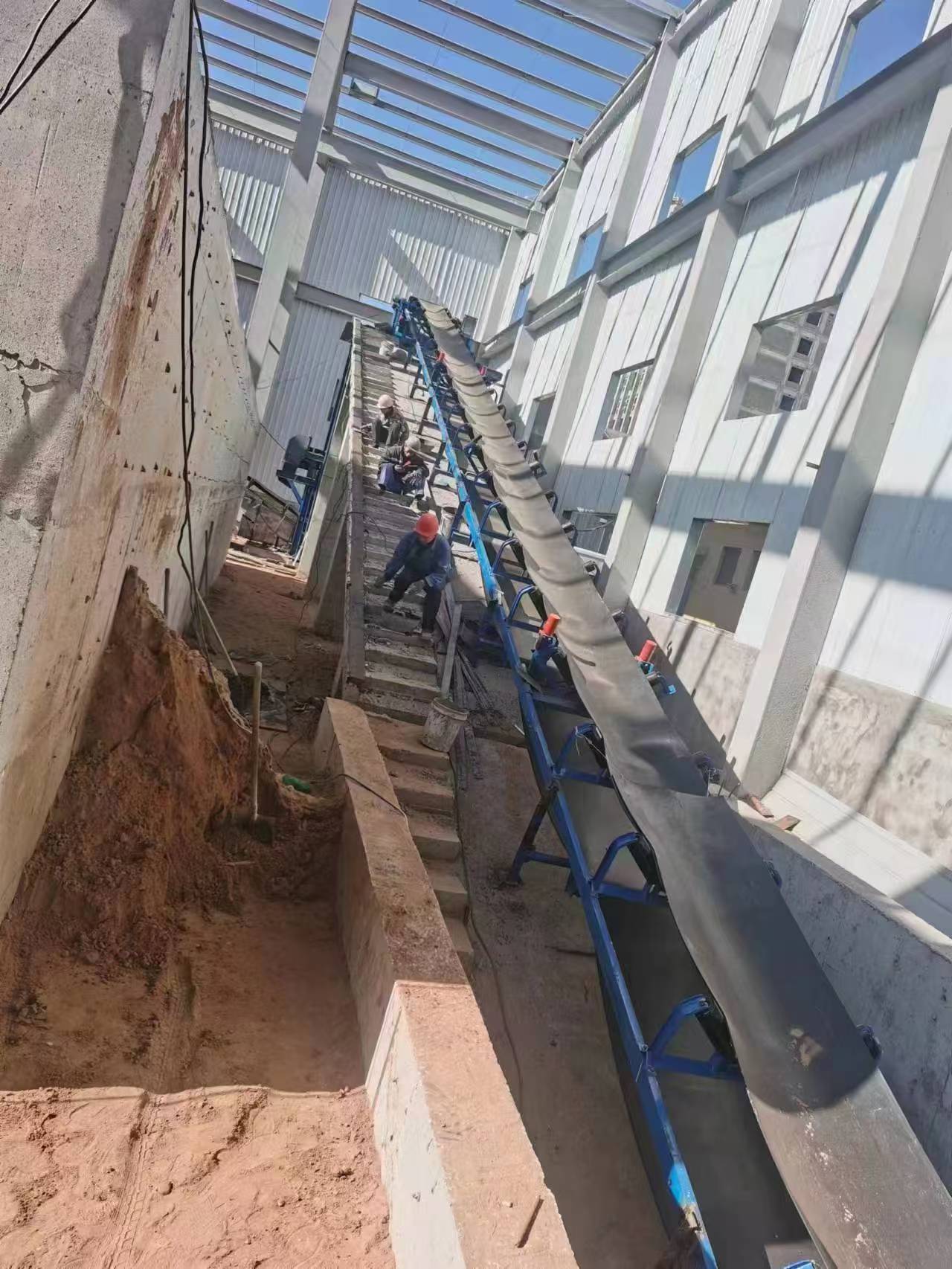 Inclined belt conveyor section at the project site.